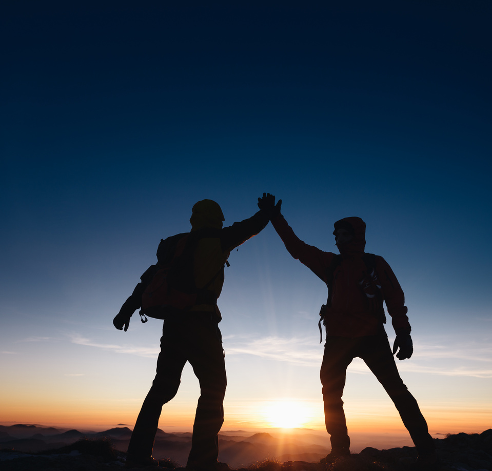 Mountaineers team giving a high five on the mountain peak